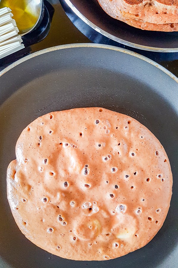 fluffy vegan pancake with red lentils cooking in a pan