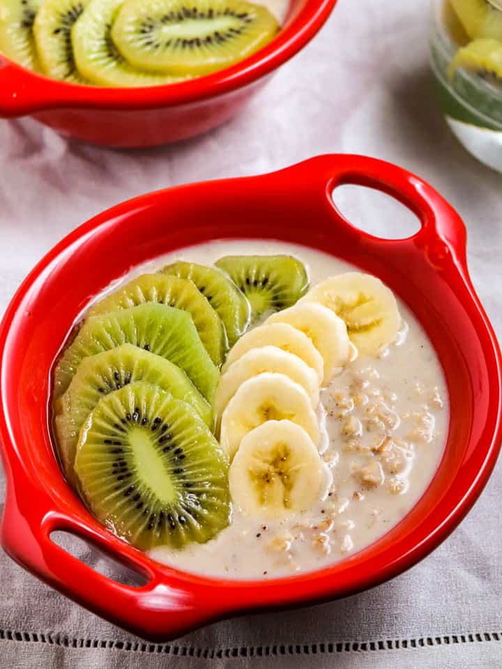 vegan overnight oats with kiwi fruit served in red bowls