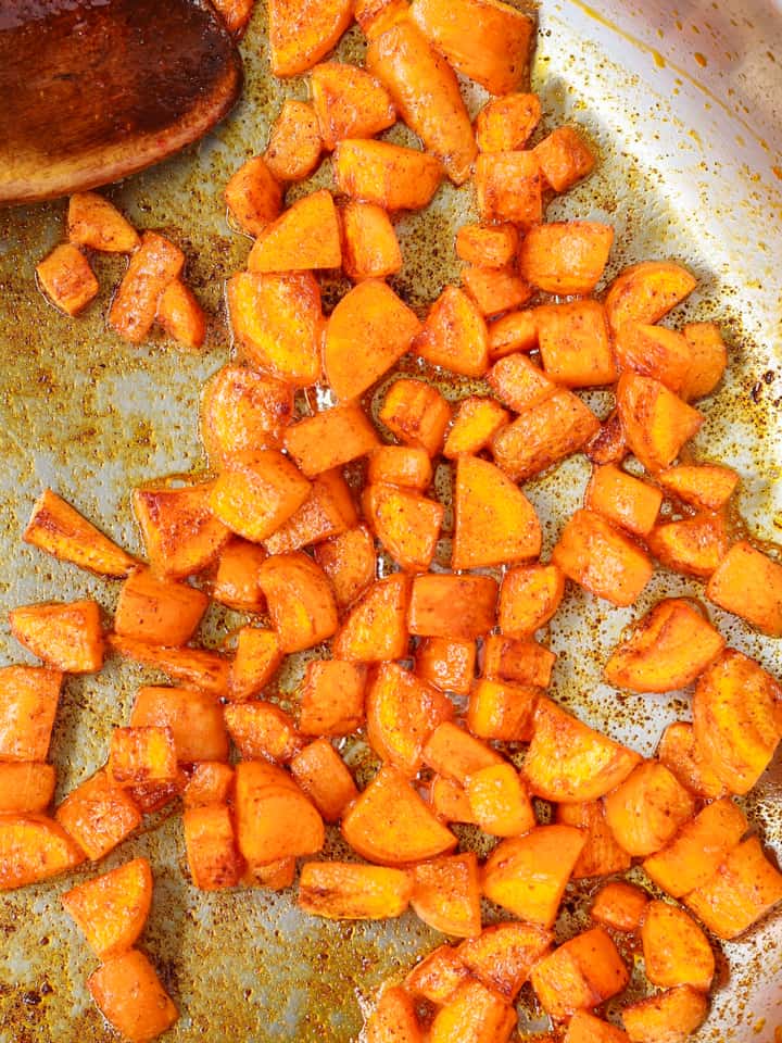 cooking diced carrots in sweet paprika spice and oil