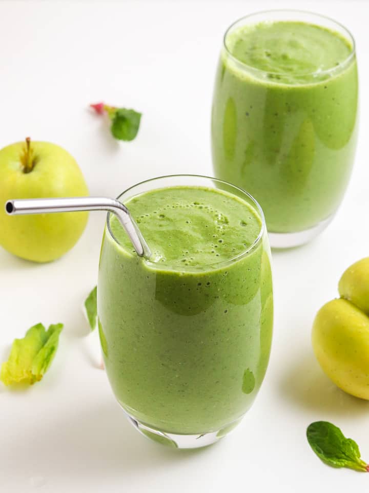 Green smoothie with green apples and a straw