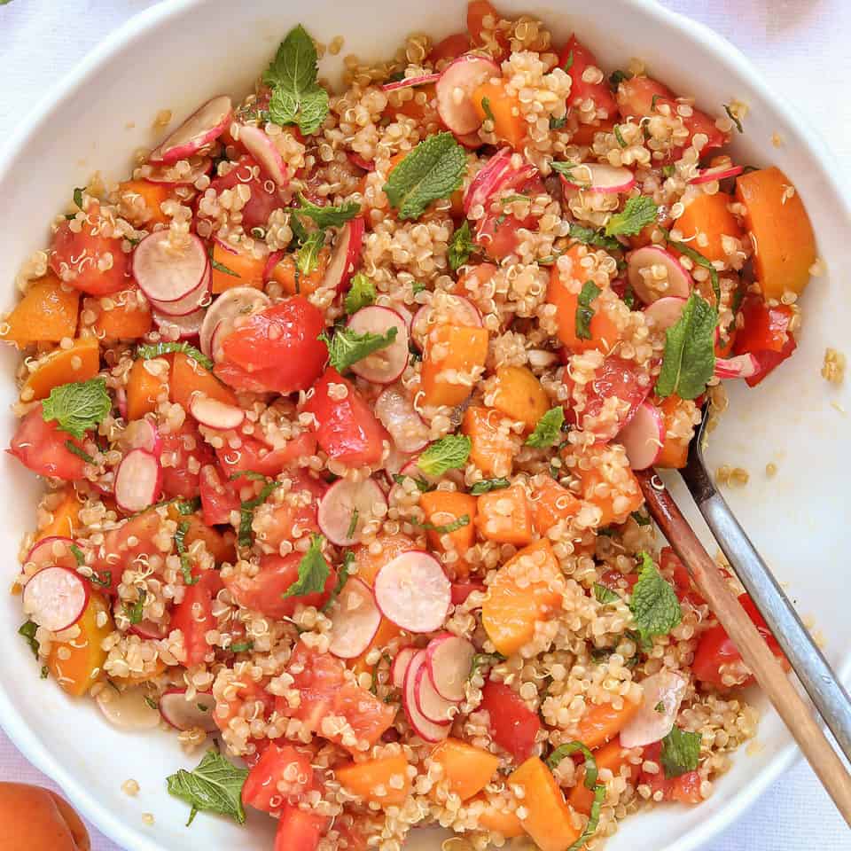 mixing quinoa apricot salad in a bowl