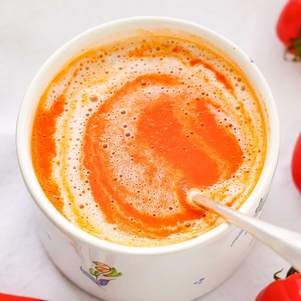 Served turmeric tomato soup with a spoon