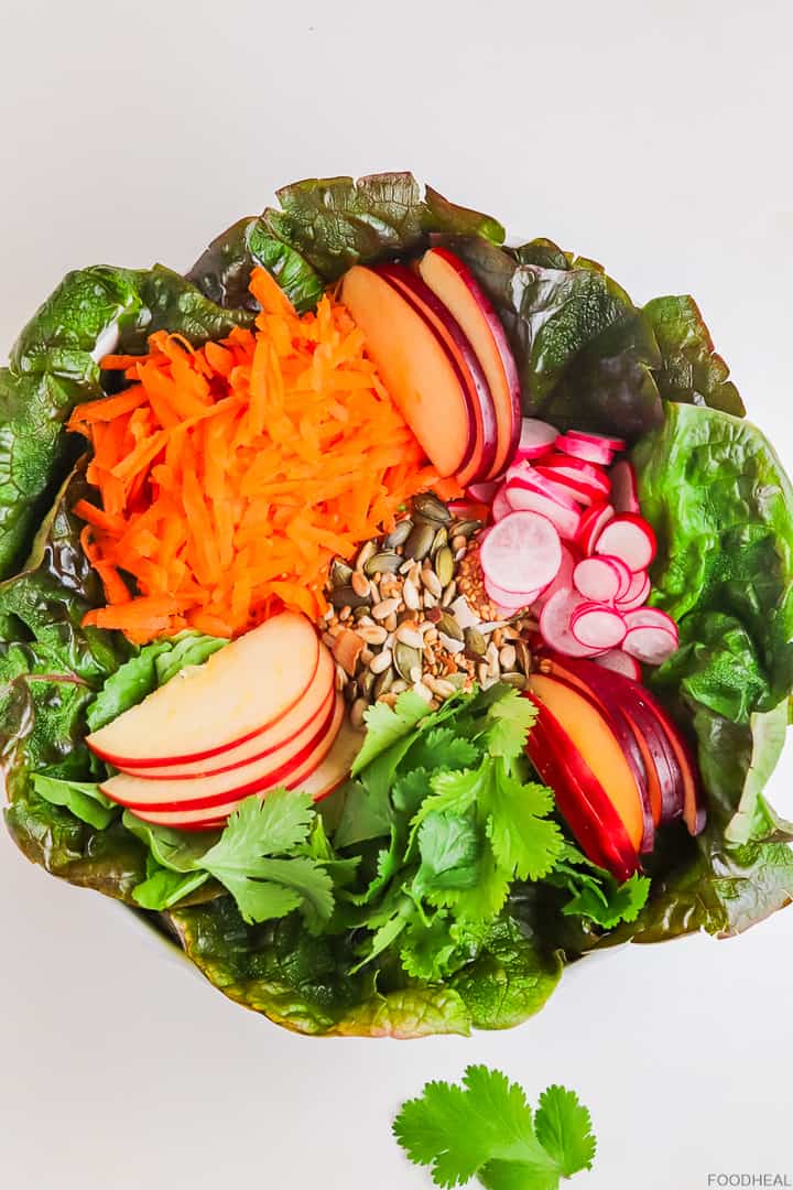 lettuce, grated carrot,radishes, seeds & apples in a salad bowl