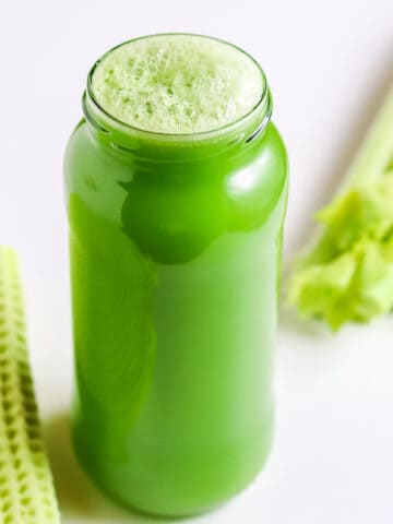Celery juice in a bottle with celery stalk
