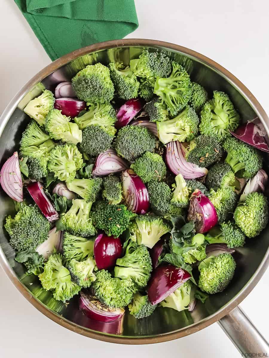 raw red onions with broccoli in a pan